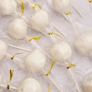 vanilla cake pops in wrappers with golden ties