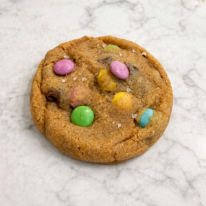Brown butter M&M cookie with chocolate chunks and colorful candy pieces, soft center and bakery-style texture